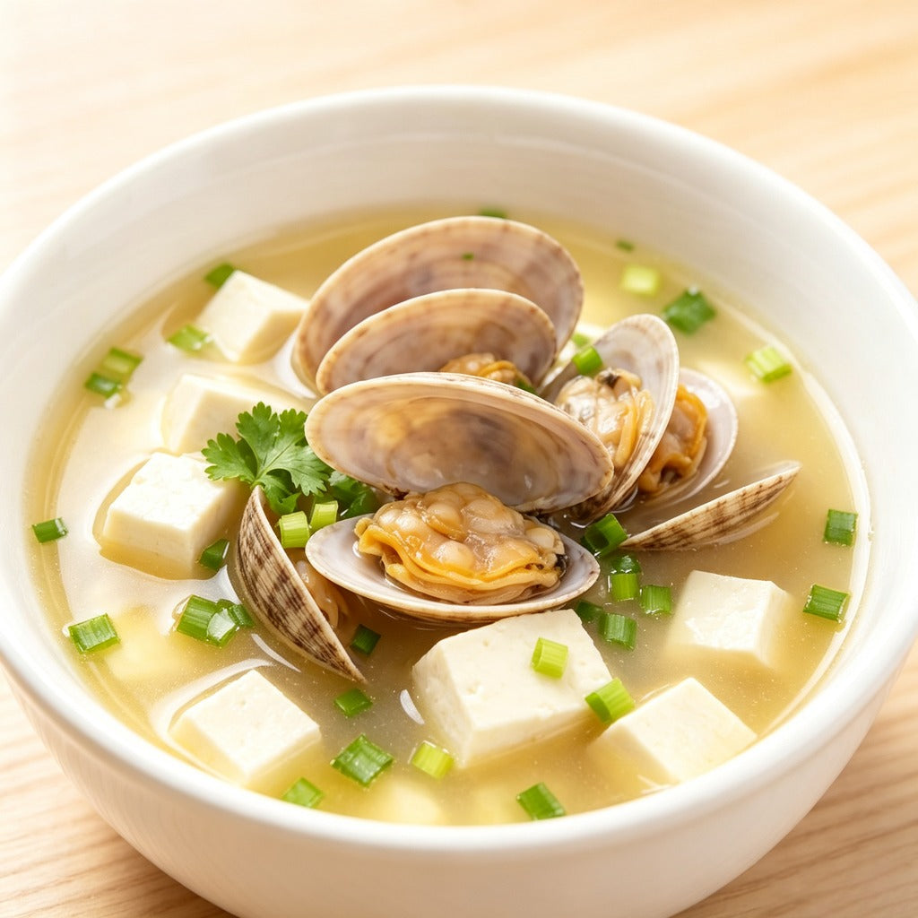 Clam and tofu soup garnished with spring onion and coriander