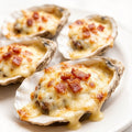 Half-shell oysters topped with melted cheese and bacon